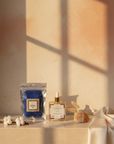 Unscented Dry Body Oil and Royal African Exfoliating Net on a stone ledge in golden-hour light
