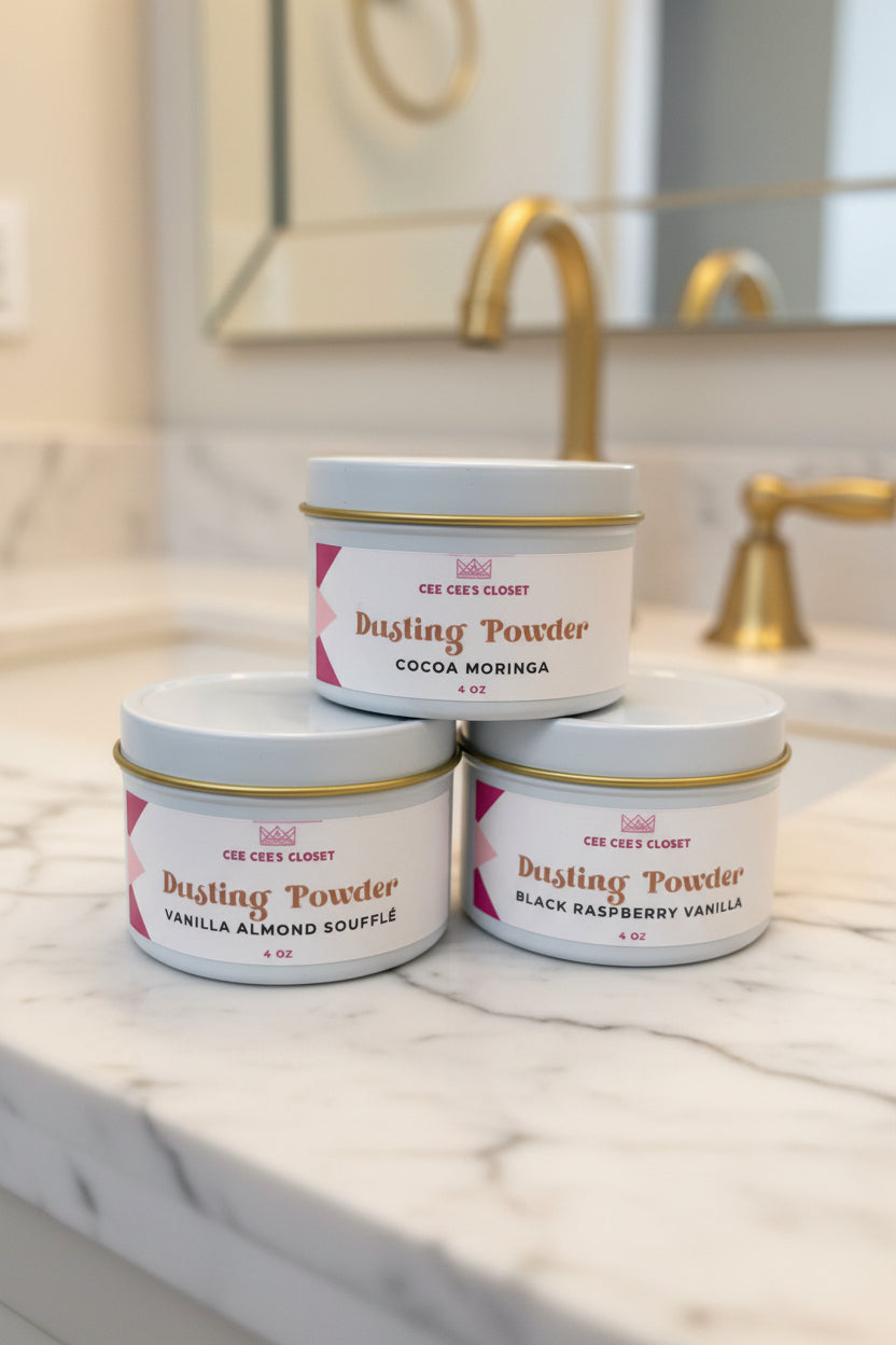 Three tins of Cee Cee's Closet NYC Dusting Powder stacked on a marble bathroom vanity