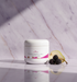 Black Raspberry Vanilla Body Butter jar on marble in soft sunlight with pear and blackberries
