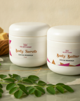 Soft Skin Set in Cocoa Moringa – Body Scrub and Body Butter on green marble with moringa leaves and jasmine